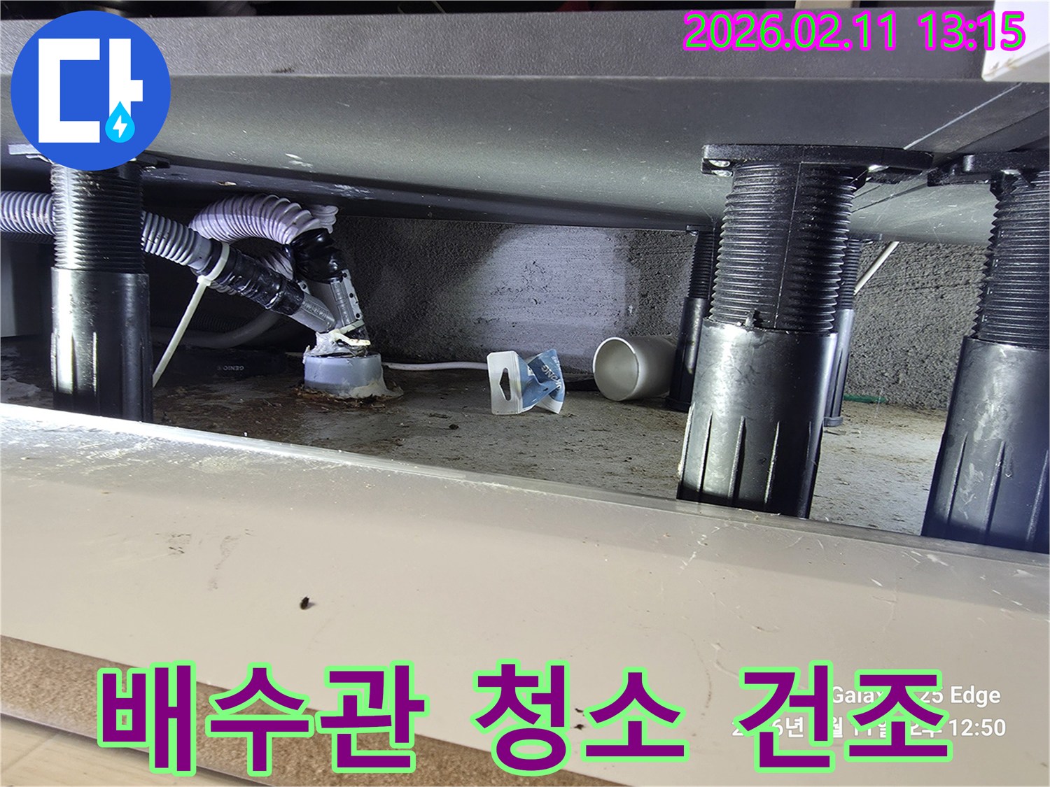 싱크대 하부 배수관 주변의 물기를 제거하고-청소 및 건조 작업을 진행하는 모습