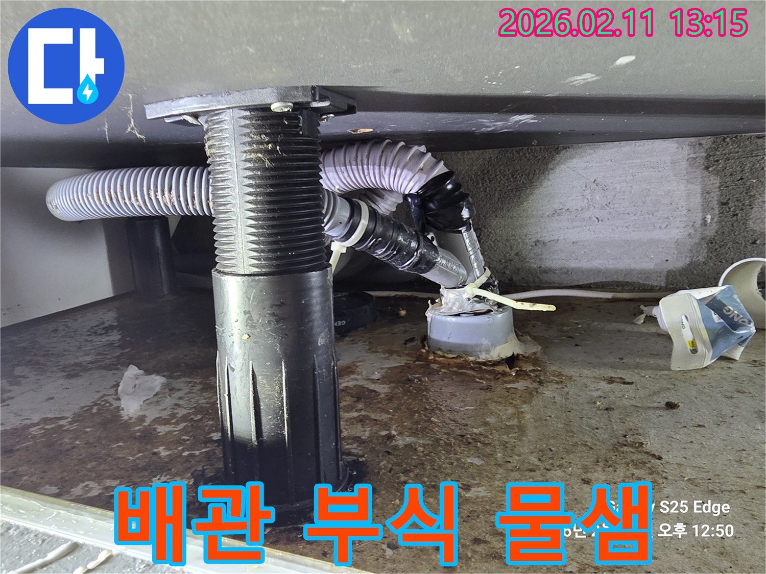 오랜 사용으로 부식된 싱크대 하부-배수관에서-물이 새어 나오는 현장을 담은 사진입니다.