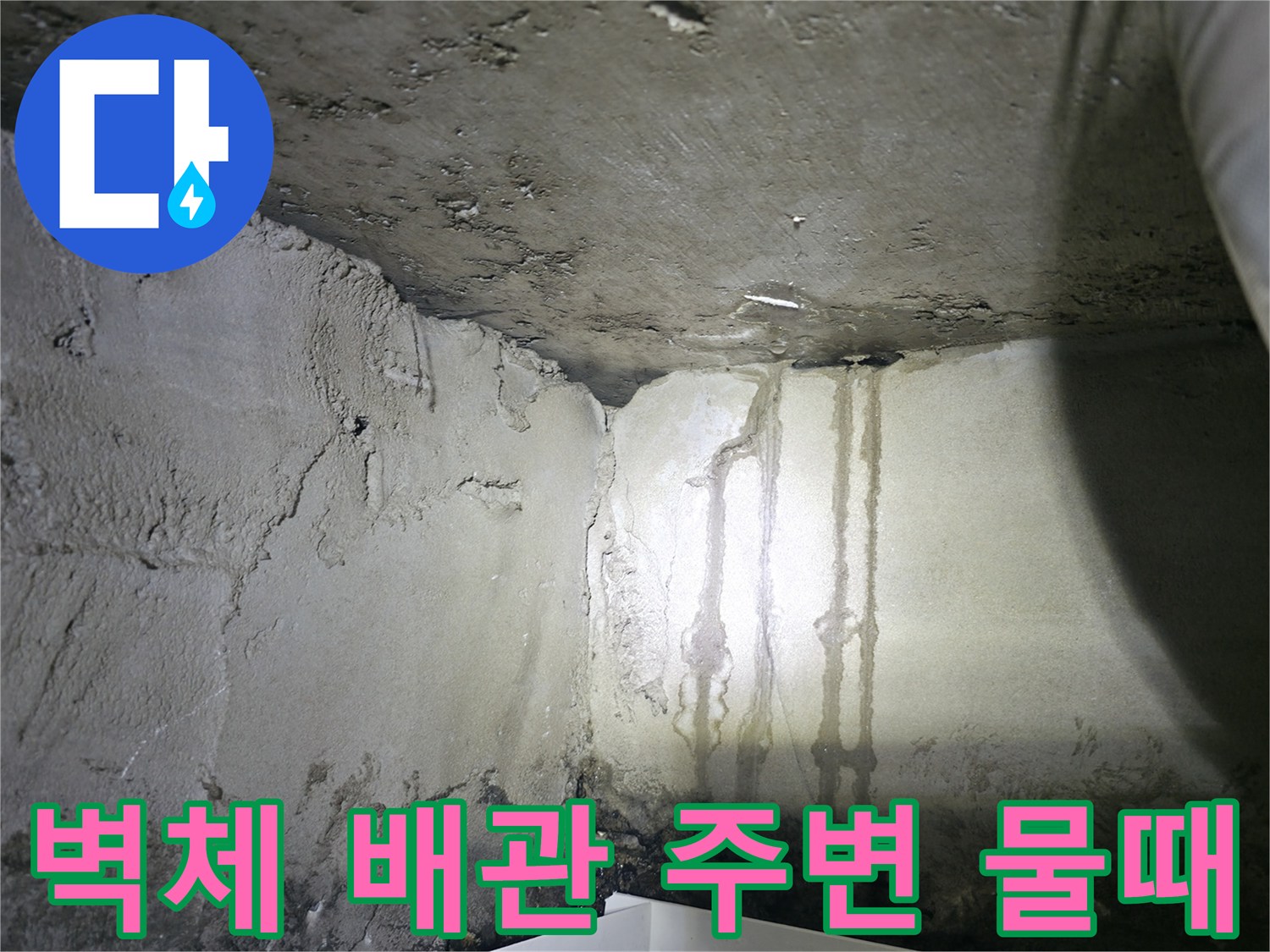 배관 연결 부위 근처의 젖은 벽면과 얼룩 상태