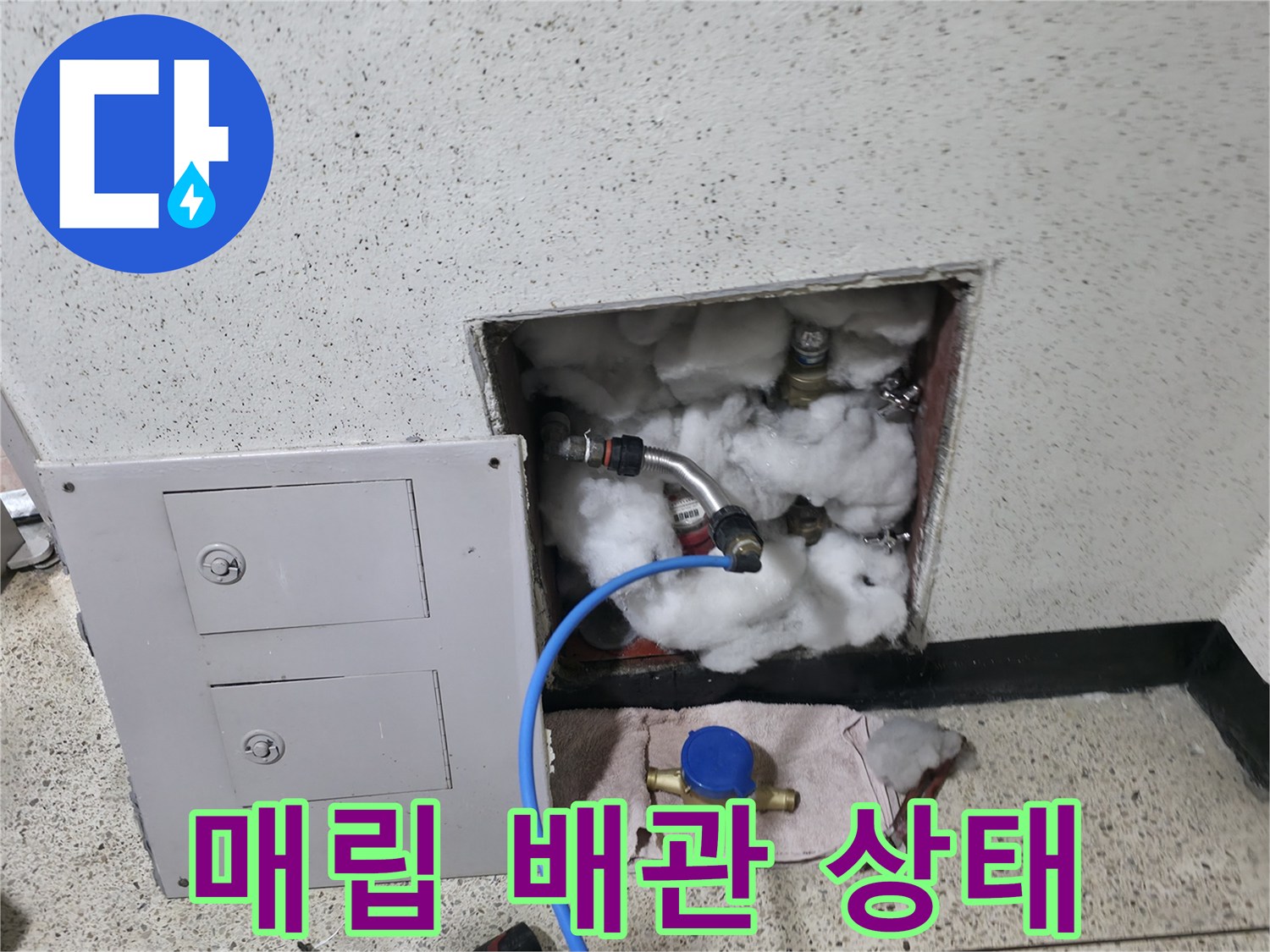 보온재로 감싸진 수도 배관의 연결 부위를 점검하는 모습입니다.