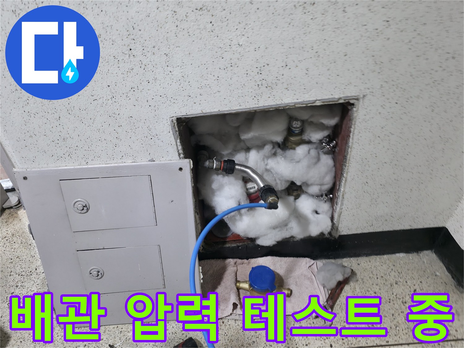 파란색 호스가 연결된 벽체 내부 배관 구조물
