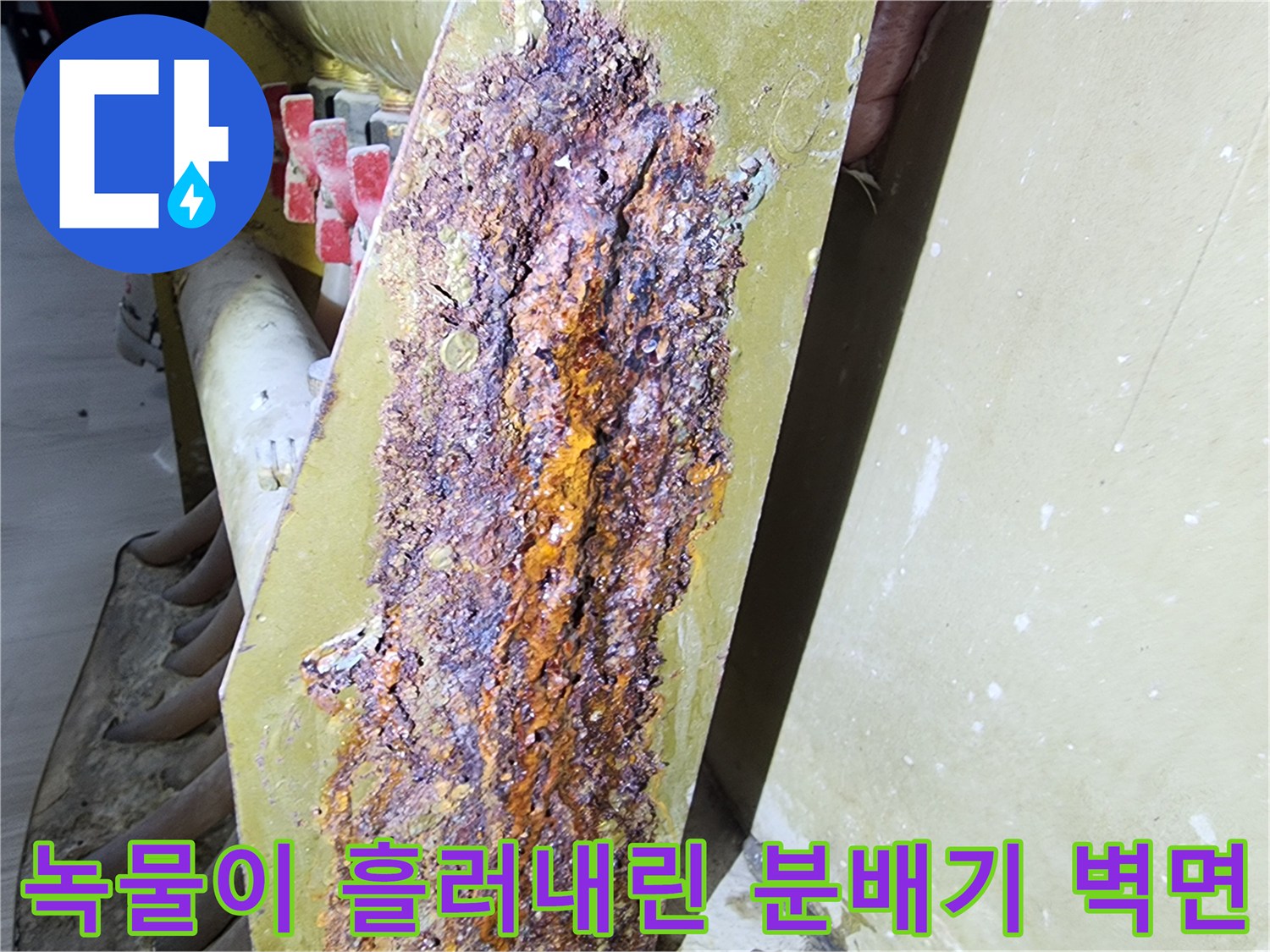 분배기 주변 벽면이 부식된 금속물로 인해 오염된 사진입니다.