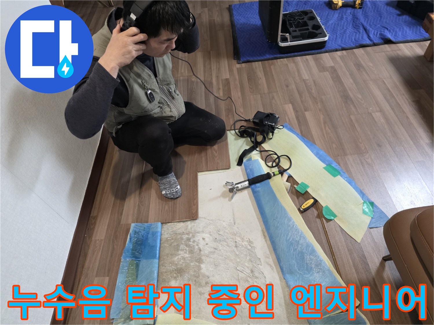 청음 장비를 활용해 바닥 아래 배관의 파열음을 찾는 전문적인 모습