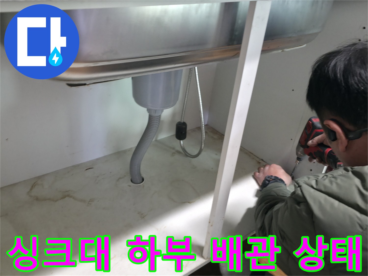 싱크대 아래 은색 주름관과 바닥 배관 연결 부위 촬영