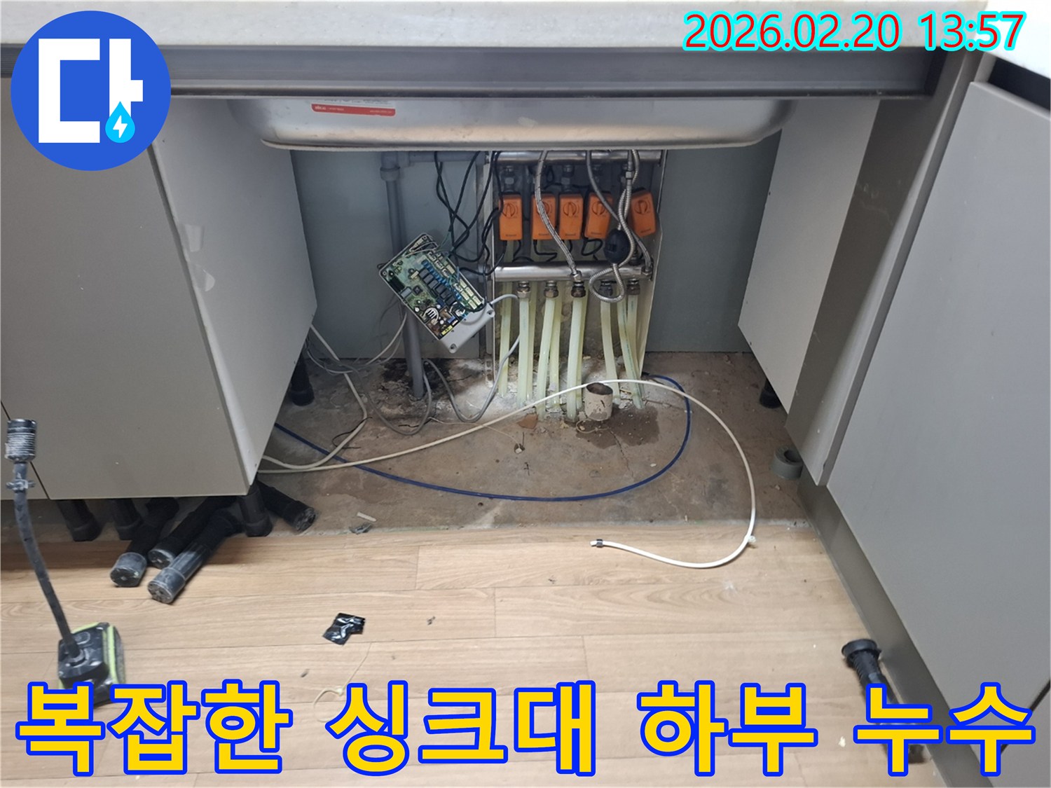싱크대-아래-배관과-전선이-얽힌-곳에서-발견된-누수-현장을-면밀히-살피는-모습입니다