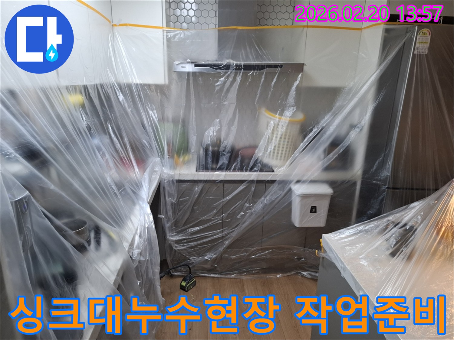이 사진은-용인 모현읍의 한 가정집 주방에서-싱크대 누수 수리 전-주변을 보호하기 위한-보양 작업이 완료된 상태를 담고 있습니다