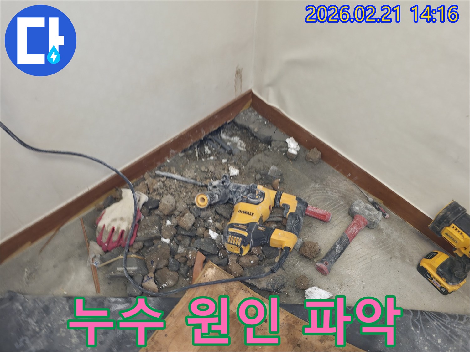 누수 원인을 파악하기 위해 바닥을 파쇄하고 있는 공사 현장-안전 장비가 함께 보입니다