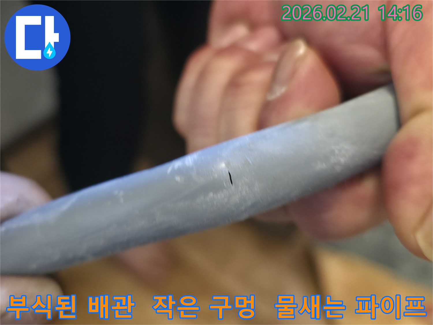 부식으로 인해 수도관에 생긴 작은 구멍을-선명하게-보여주며-누수의 직접적인-원인을-제시하는-사진입니다.