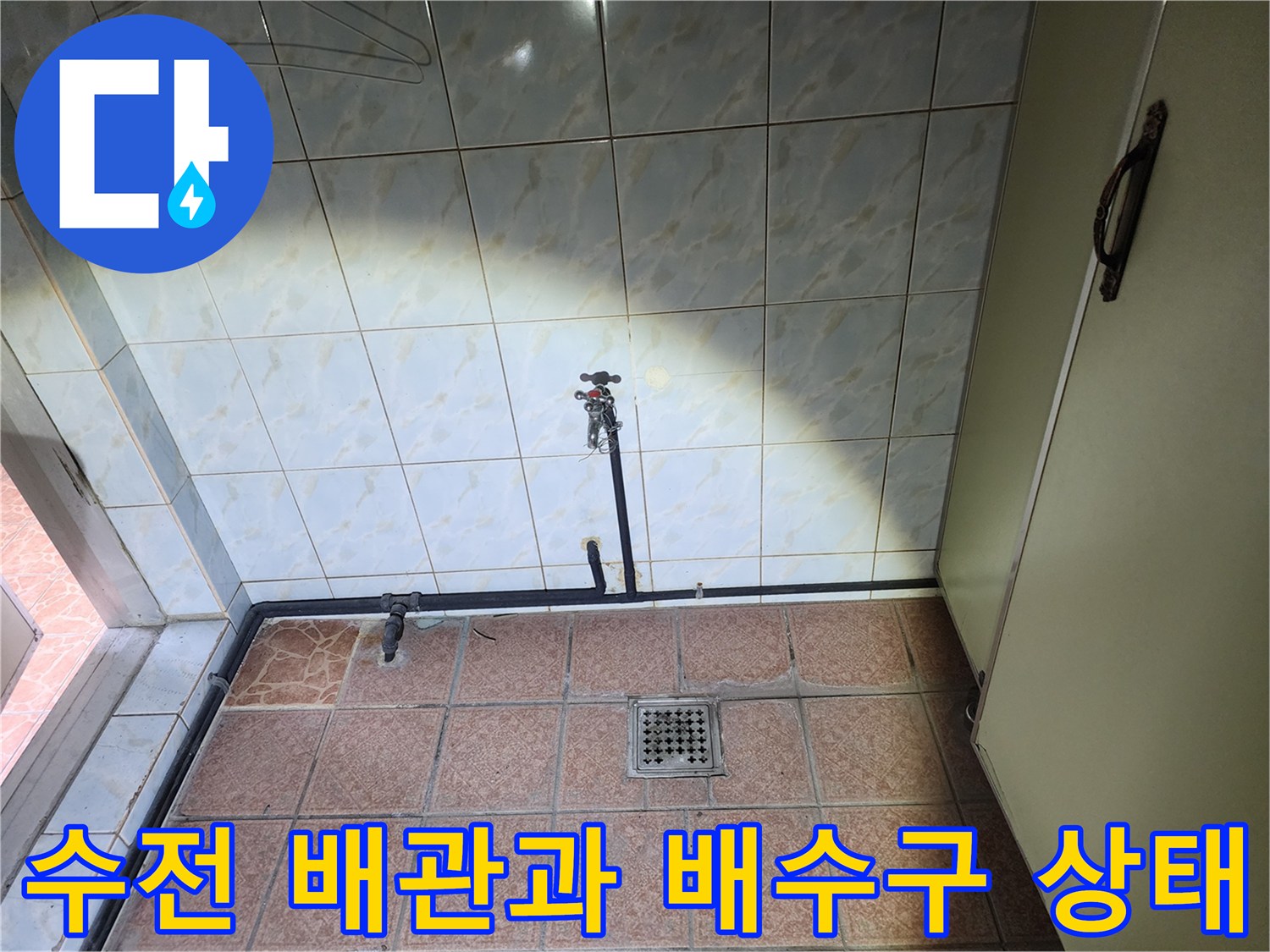 벽면 수전 아래로 연결된 배관과 바닥 배수구 근접 촬영