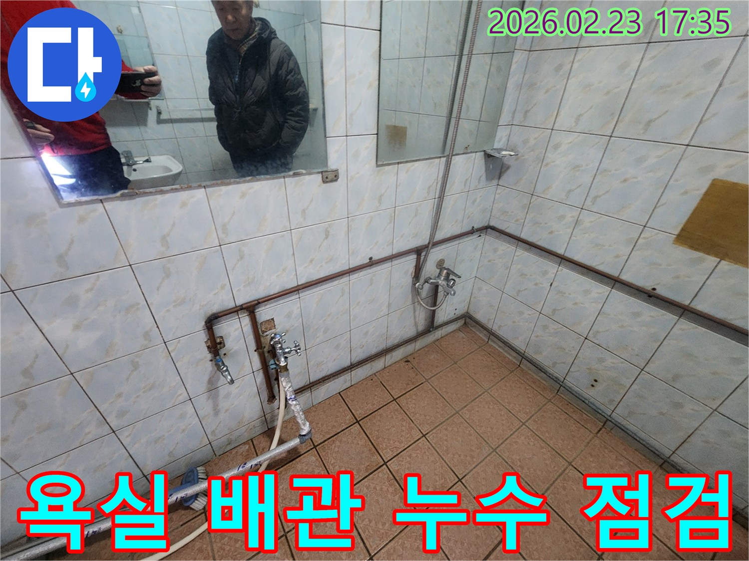 욕실 내부-노출된 수도 배관과-누수 확인을 위한-점검 장비 연결 모습