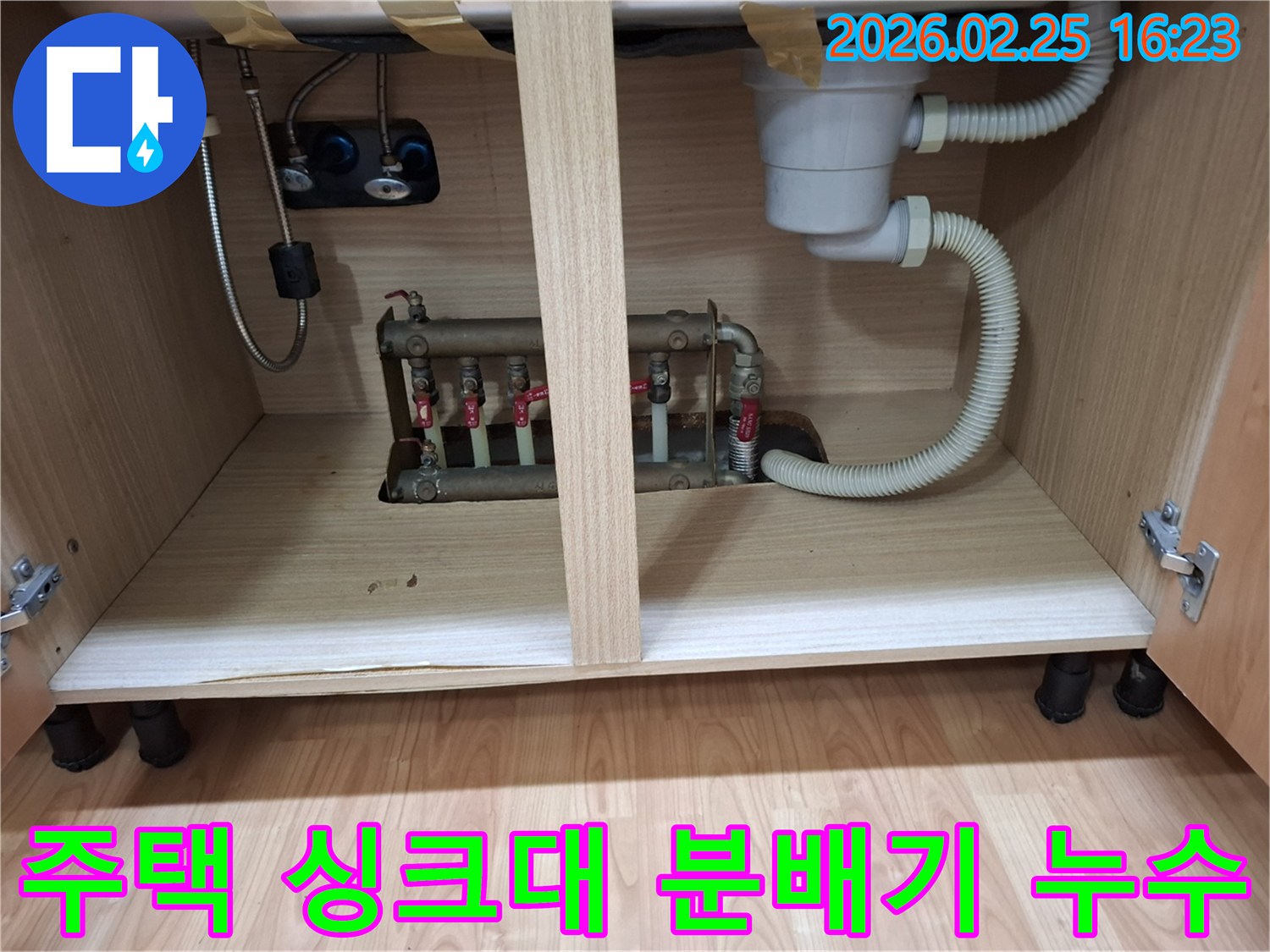 주택 싱크대 하부장 내부에 위치한 보일러 분배기에서 발생하는 누수 현장 사진입니다