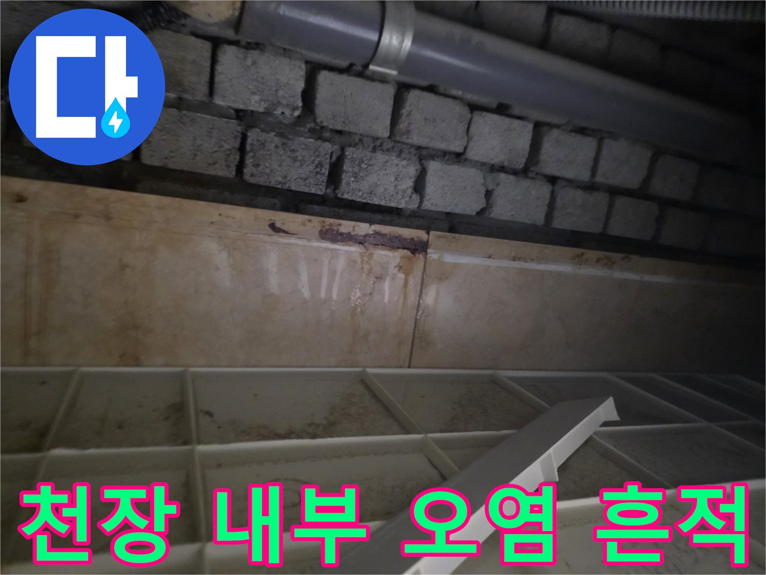배관 주변의 습한 콘크리트 블록과 배수관 연결부
