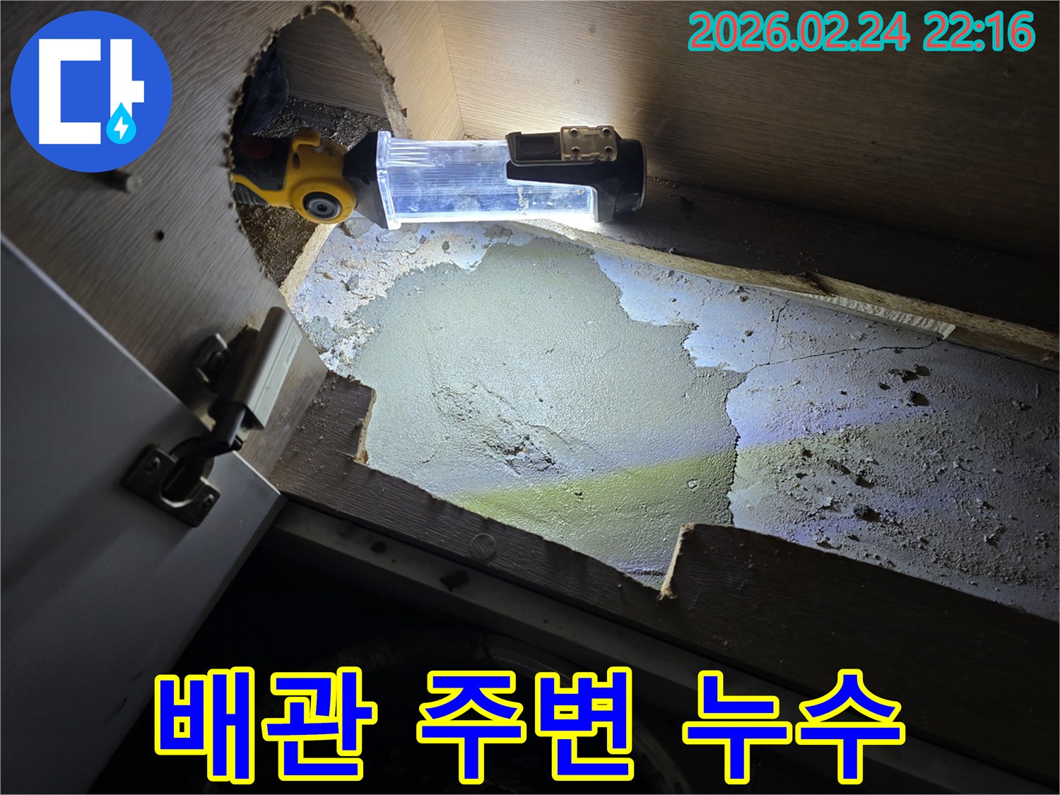 누수-엔지니어가-어둡고-좁은-배관-주변에서-누수-흔적을-찾기-위해-조명으로-밝혀-정밀하게-조사하는-모습