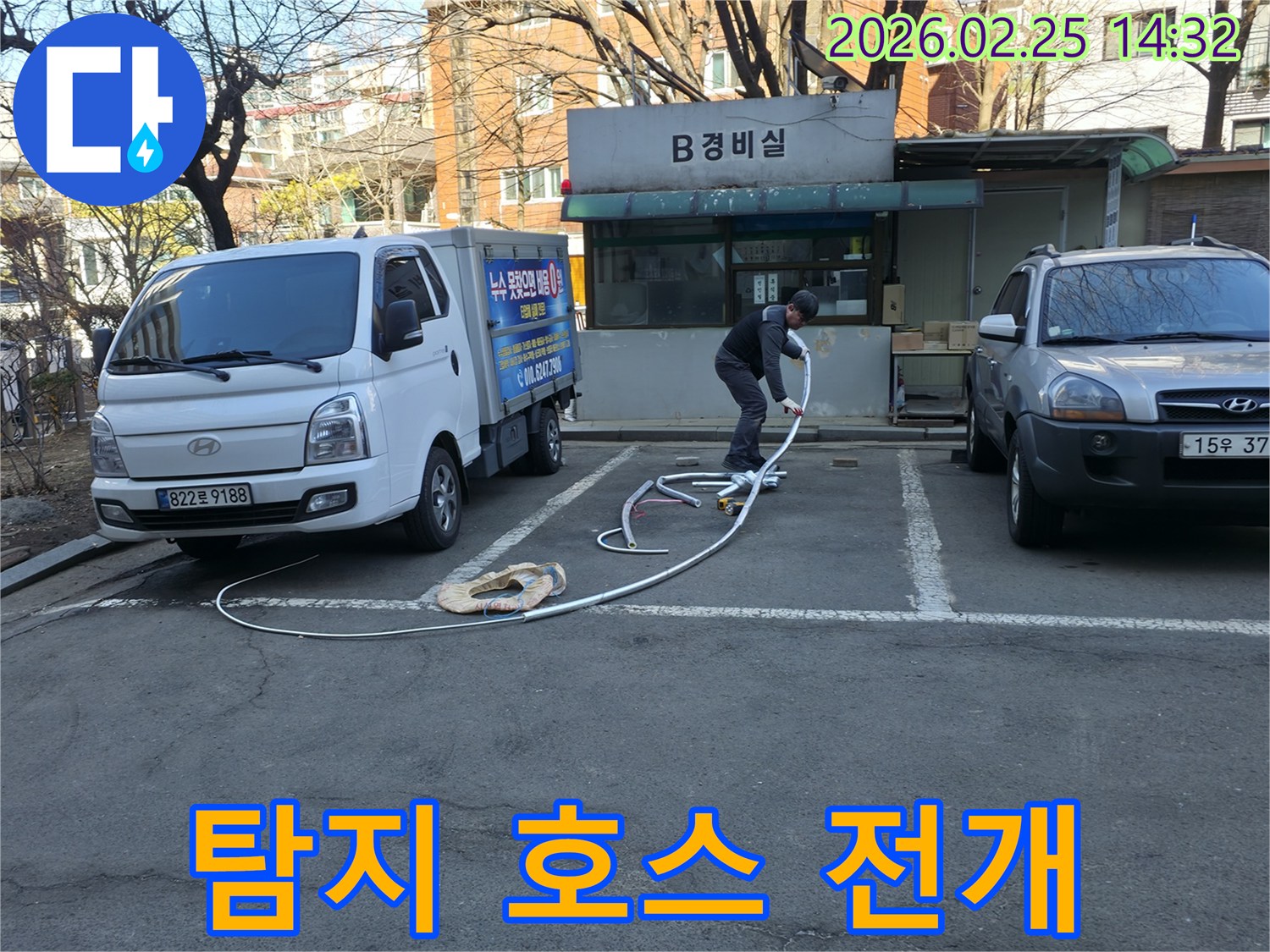 누수 전문 엔지니어가 건물 내부의 배관을 탐지할-긴 호스를 능숙하게 펼치며 준비하고 있습니다.