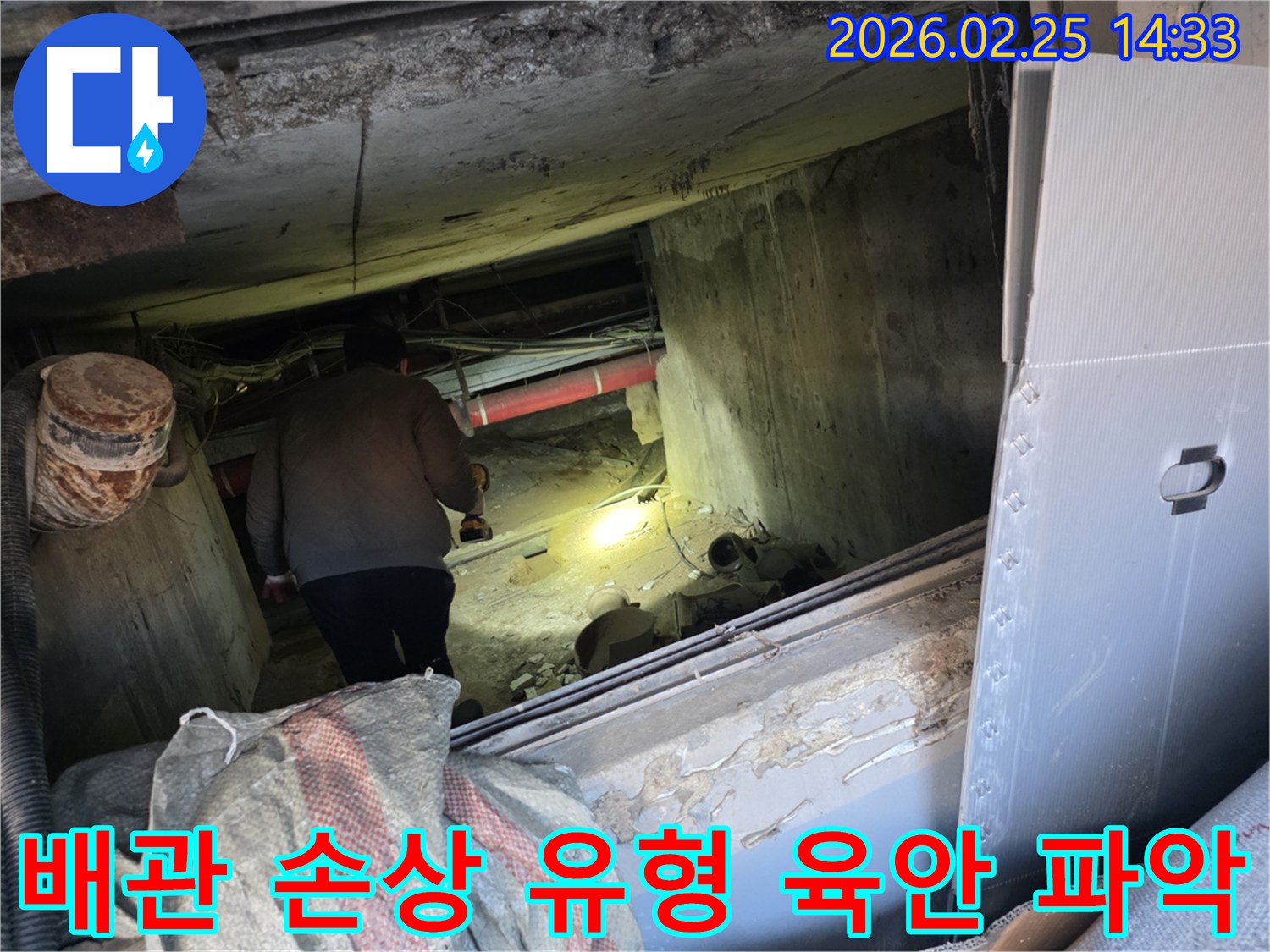 누수 전문 엔지니어가-어두운 공간에서-손전등을 비춰가며-배관의 미세한 손상 유형을-육안으로 정밀하게-확인하는 중요한 장면입니다.