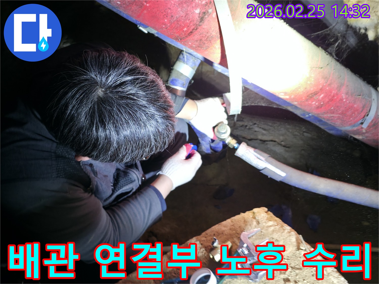 숙련된 누수 기술자가 좁은 공간에서 손전등을 비추며 노후된 배관-연결 부위를 정밀하게 점검하고-수리하고 있습니다-배관누수해결-전문가수리