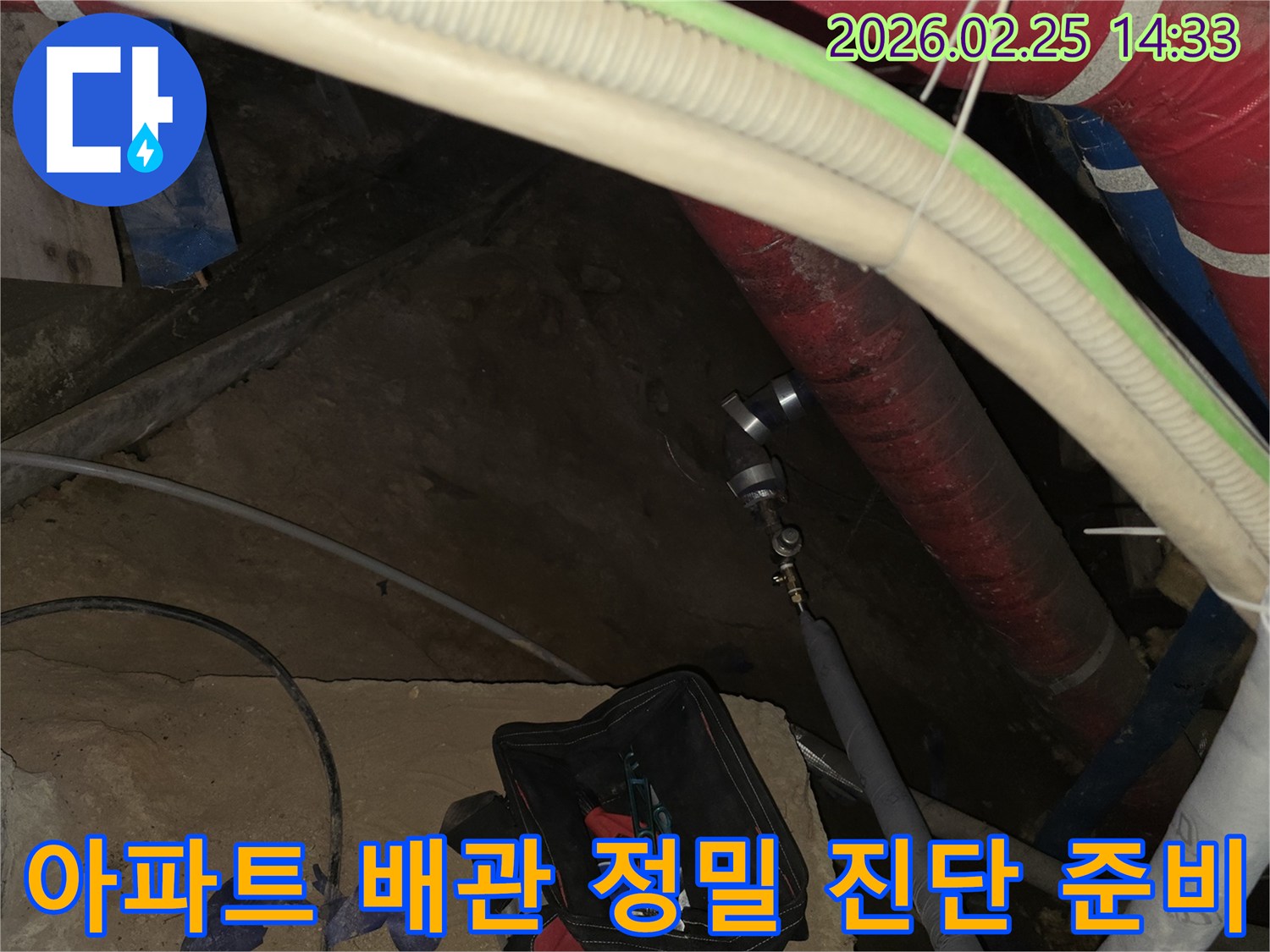 아파트 층간 누수 원인을-정확히 파악하기 위해-배관에 탐지 장비를 연결하는-전문가의 작업 현장입니다.