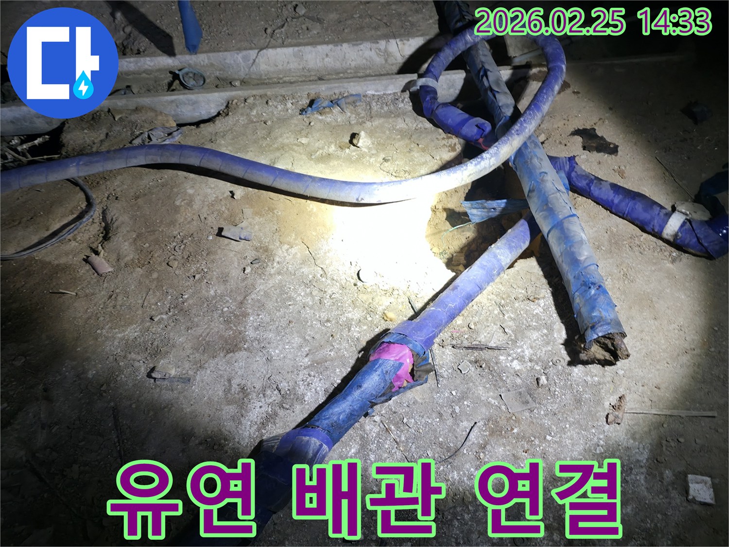 어두운 공간에서-손상된 유연 배관을-새로운 연결 부위로-정밀하게 보수하는-전문가의 작업 현장입니다.