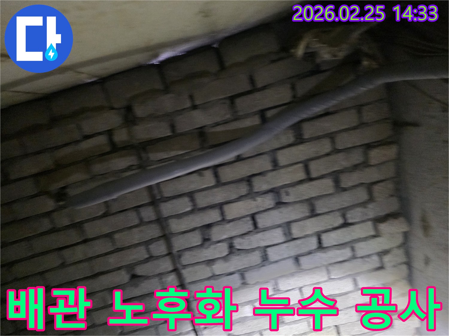 어두운 벽돌 벽면을 배경으로-노후된 배관에서 발생한-누수 공사를 위해-정밀하게 검사되는 현장 이미지입니다.
