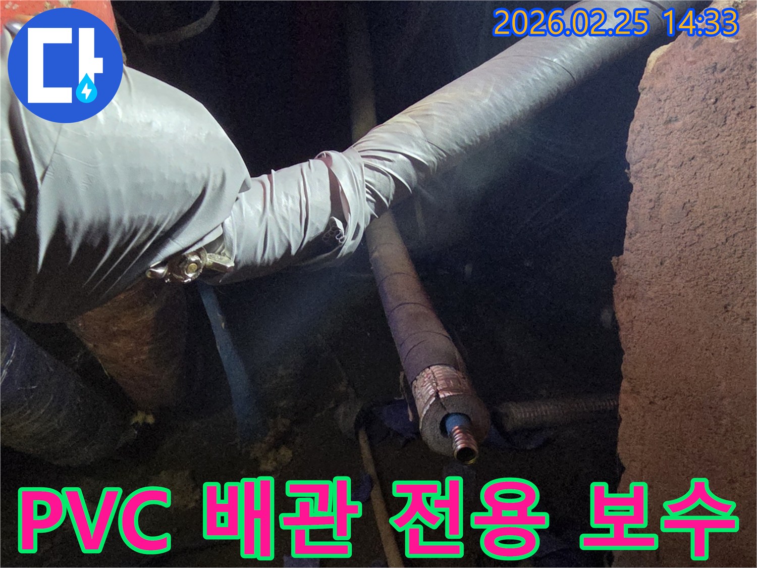 어두운 작업 공간에서-장갑을 낀 손이-PVC 배관의-손상된 부분을-전용 접착제로-견고하게 보수하는-모습을 담고 있습니다