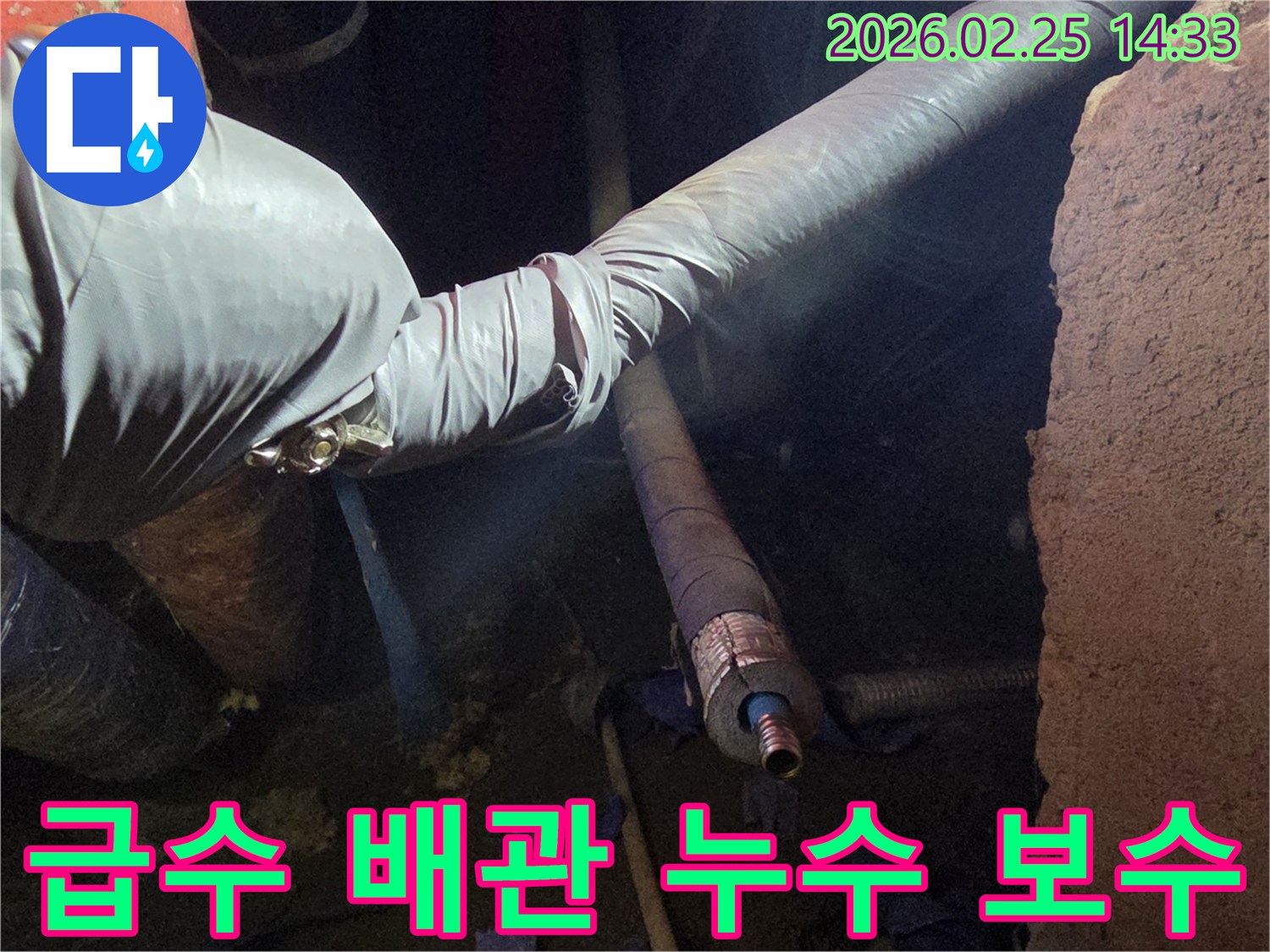 어두운 작업 공간에서-장갑을 낀 손이-급수 배관의-누수 지점을-정확히 찾아내어-보수하는 모습입니다