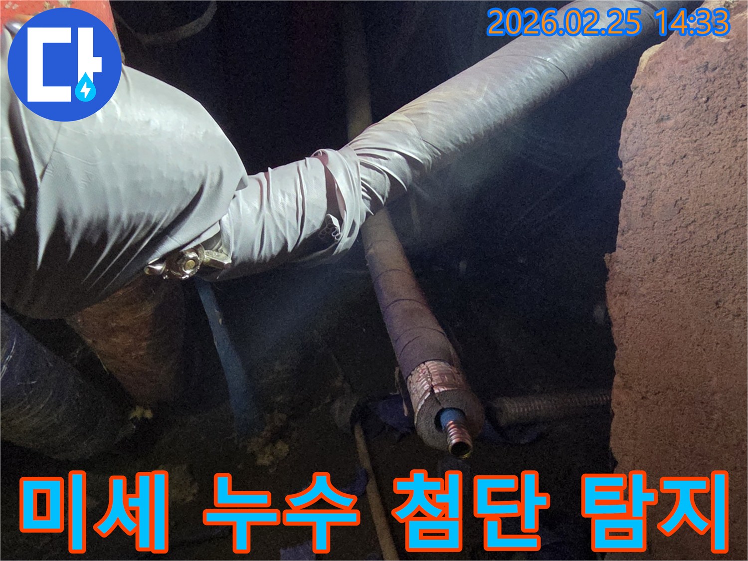 어두운 작업 공간에서-장갑을 낀 손이-최첨단 탐지 장비를-활용하여-배관의 미세한 누수 지점을-정확하게 찾아내는-모습입니다