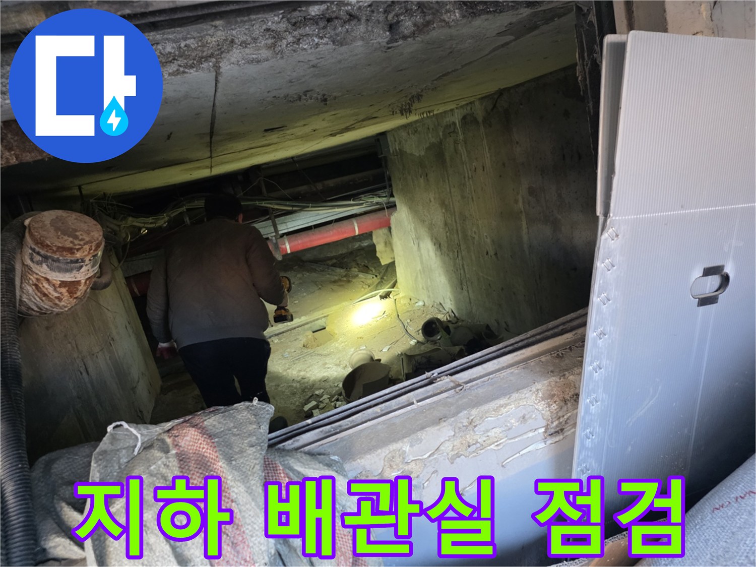 어두운 지하 배관 공간 내 작업 모습입니다.