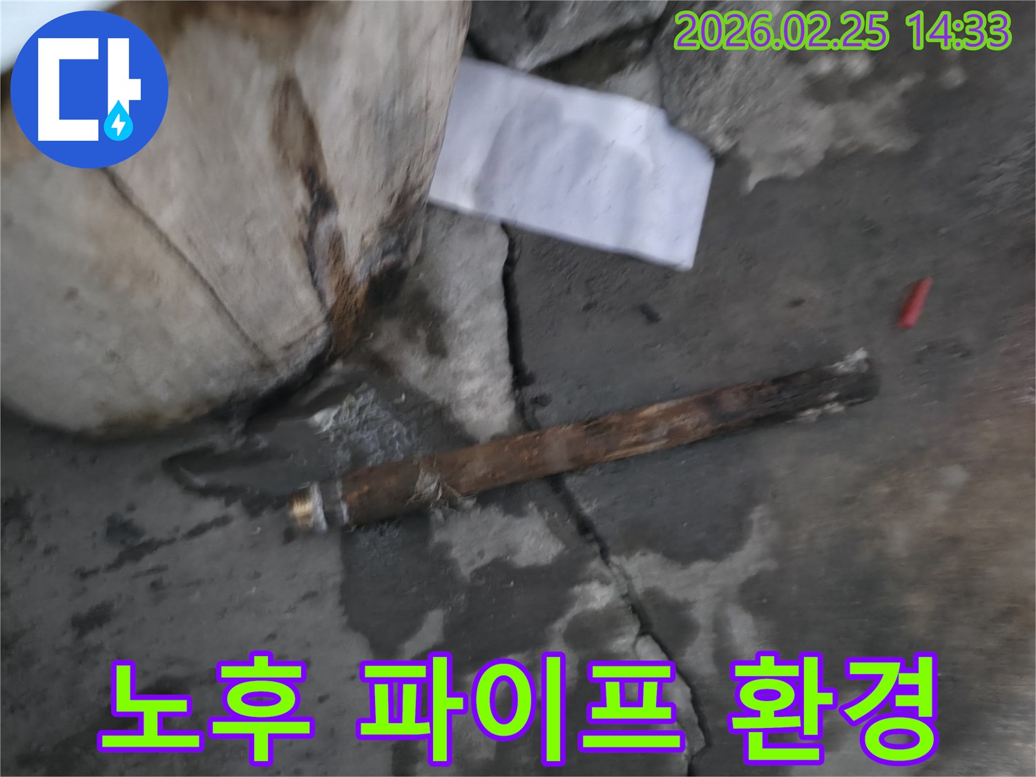 오래되어 부식된-파열된 파이프가-젖은 바닥에 놓여있는-누수 공사 현장 사진입니다.