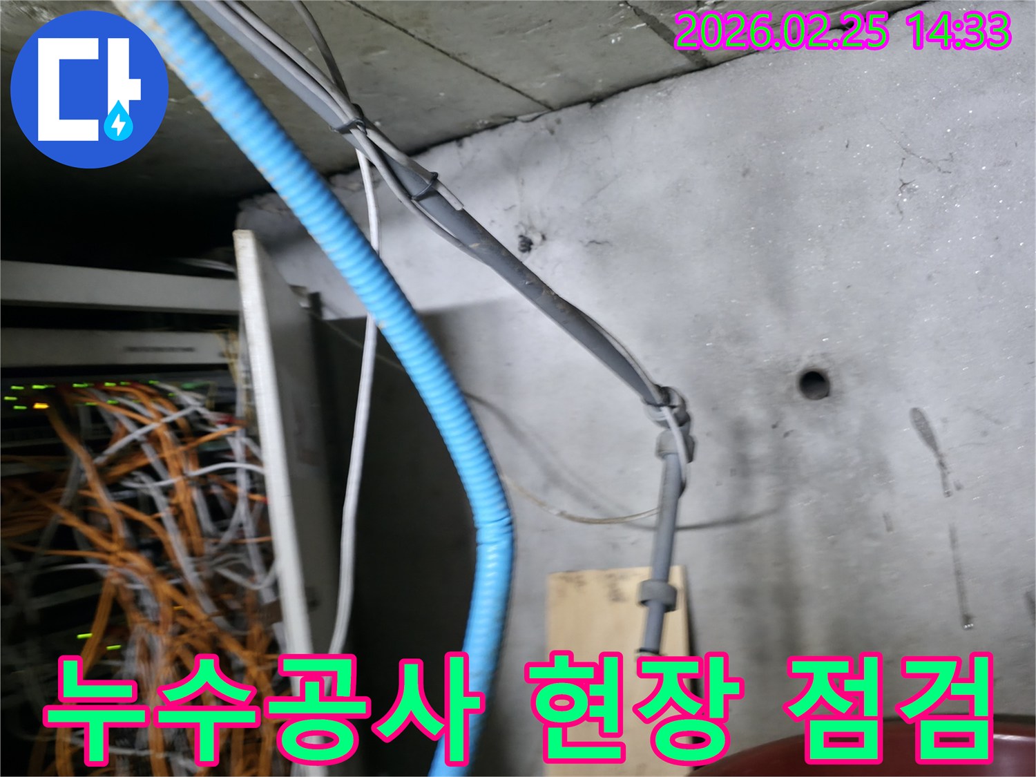 이 이미지는 누수 공사 현장에서-복잡한 배관과 케이블을-점검하며 시공 계획을 세우는-전문가의 모습을 보여줍니다