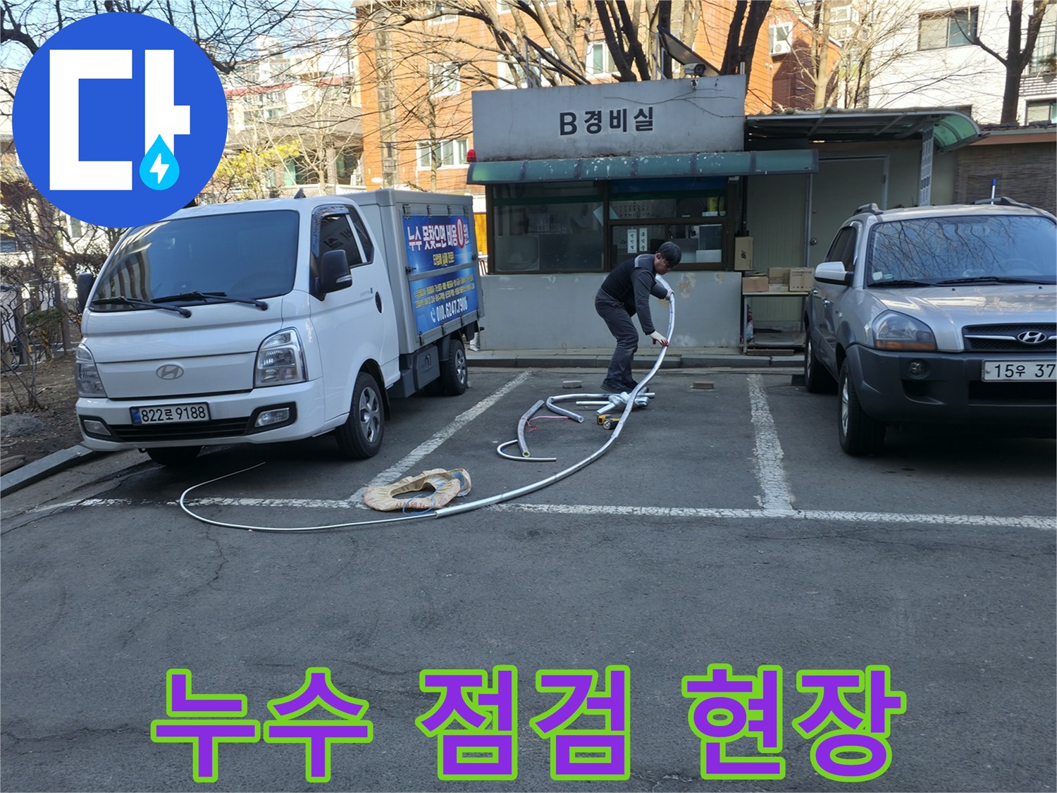 지하 경비실 앞 작업 차량과 바닥의 흰색 호스 연결 상태
