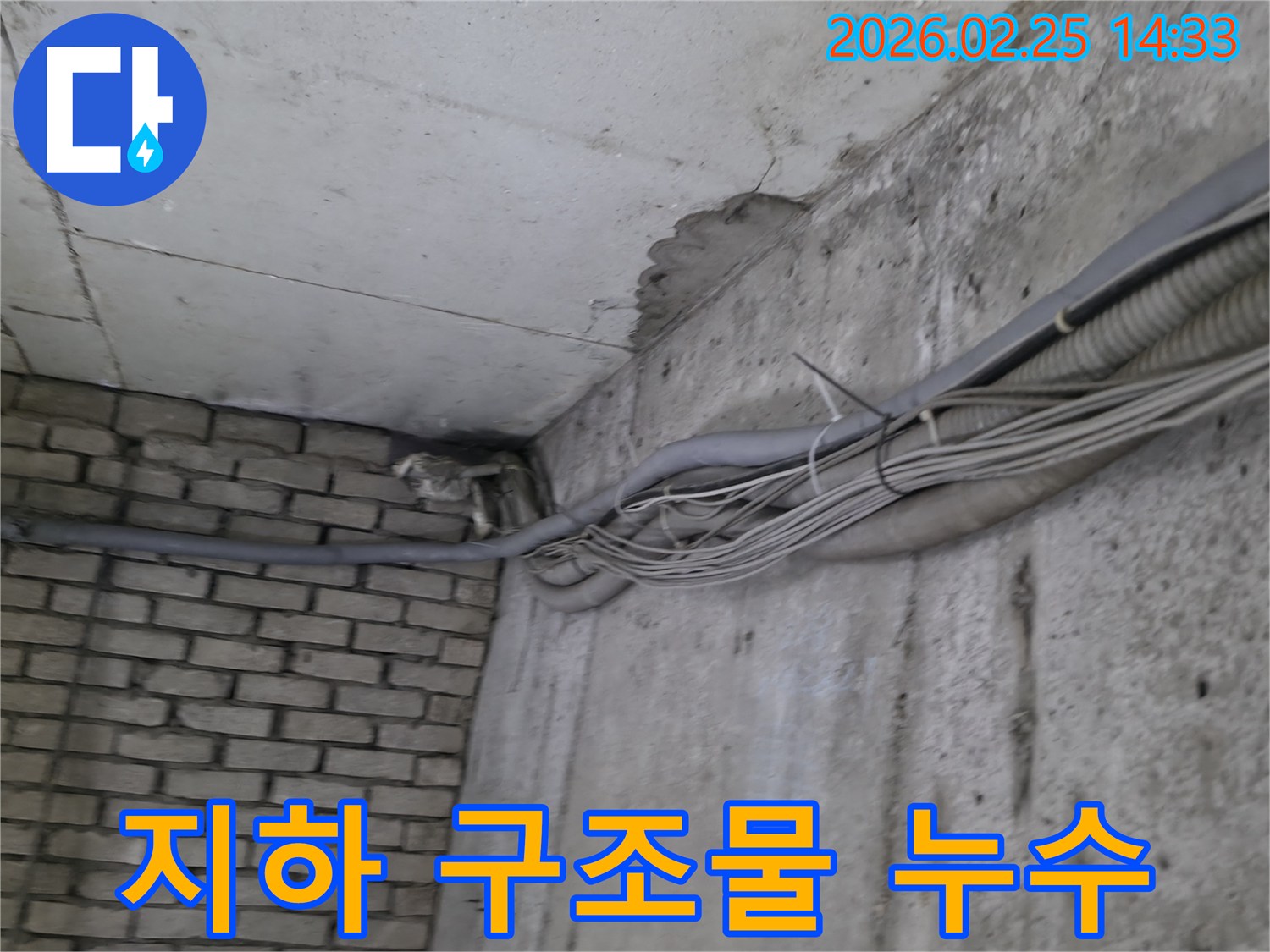 지하 벽면의-콘크리트와-벽돌 벽이 만나는-지점에서-발견된-오랜 누수로 인한-물자국과-주변의 복잡한 배관