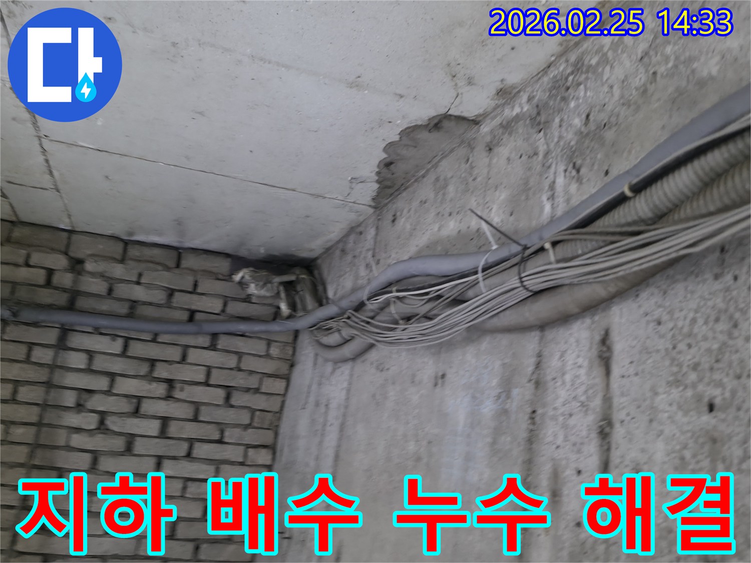 지하 벽면의-콘크리트와-벽돌 벽이 만나는-지점에서-발견된-오랜 누수로 인한-물자국과-주변의 복잡한 배관