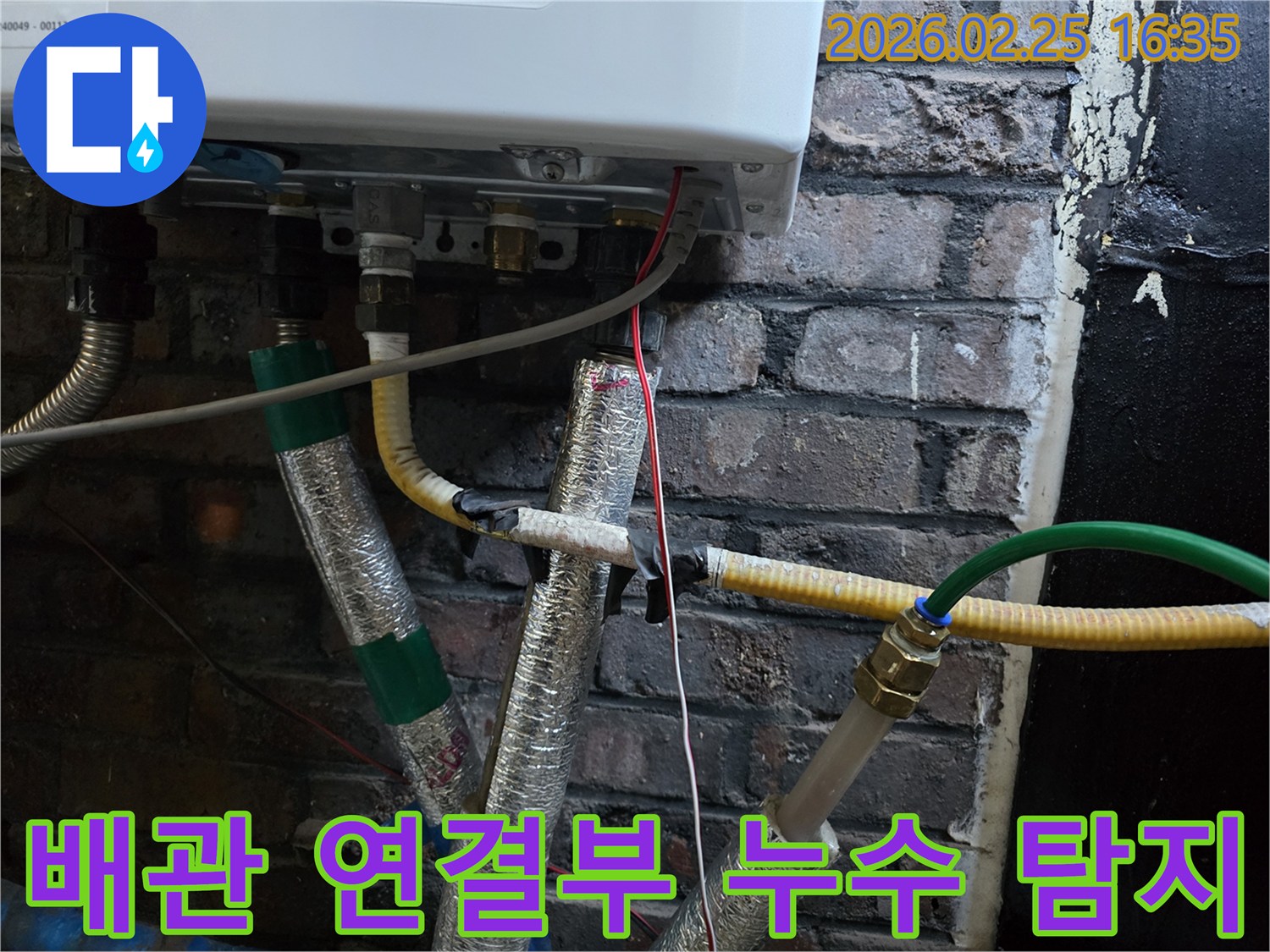 이 사진은-보일러 하단에-연결된-여러 배관의-이음새 부분을-확대하여-보여주며-누수 탐지를 위한-정밀한 관찰이-진행되고-있음을-암시합니다.