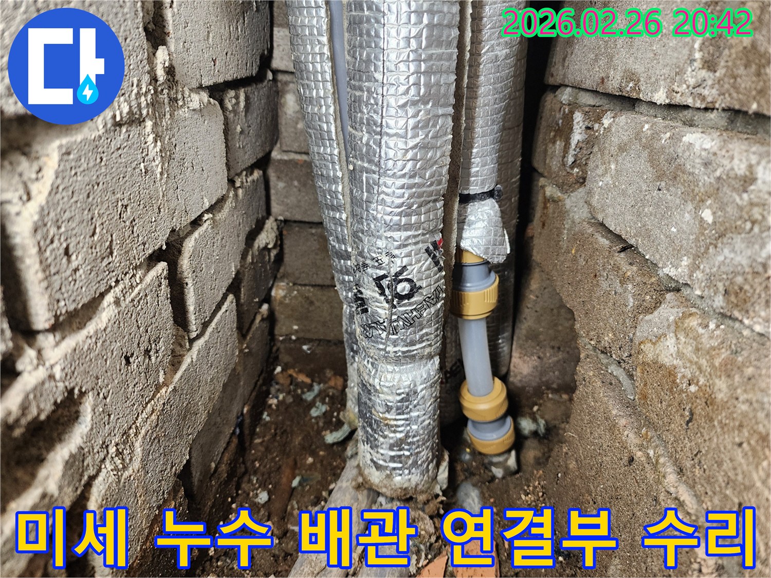 벽 틈새에 설치된-단열 배관의-손상된 연결 부위를-새로운 부품으로-교체하는 현장입니다.