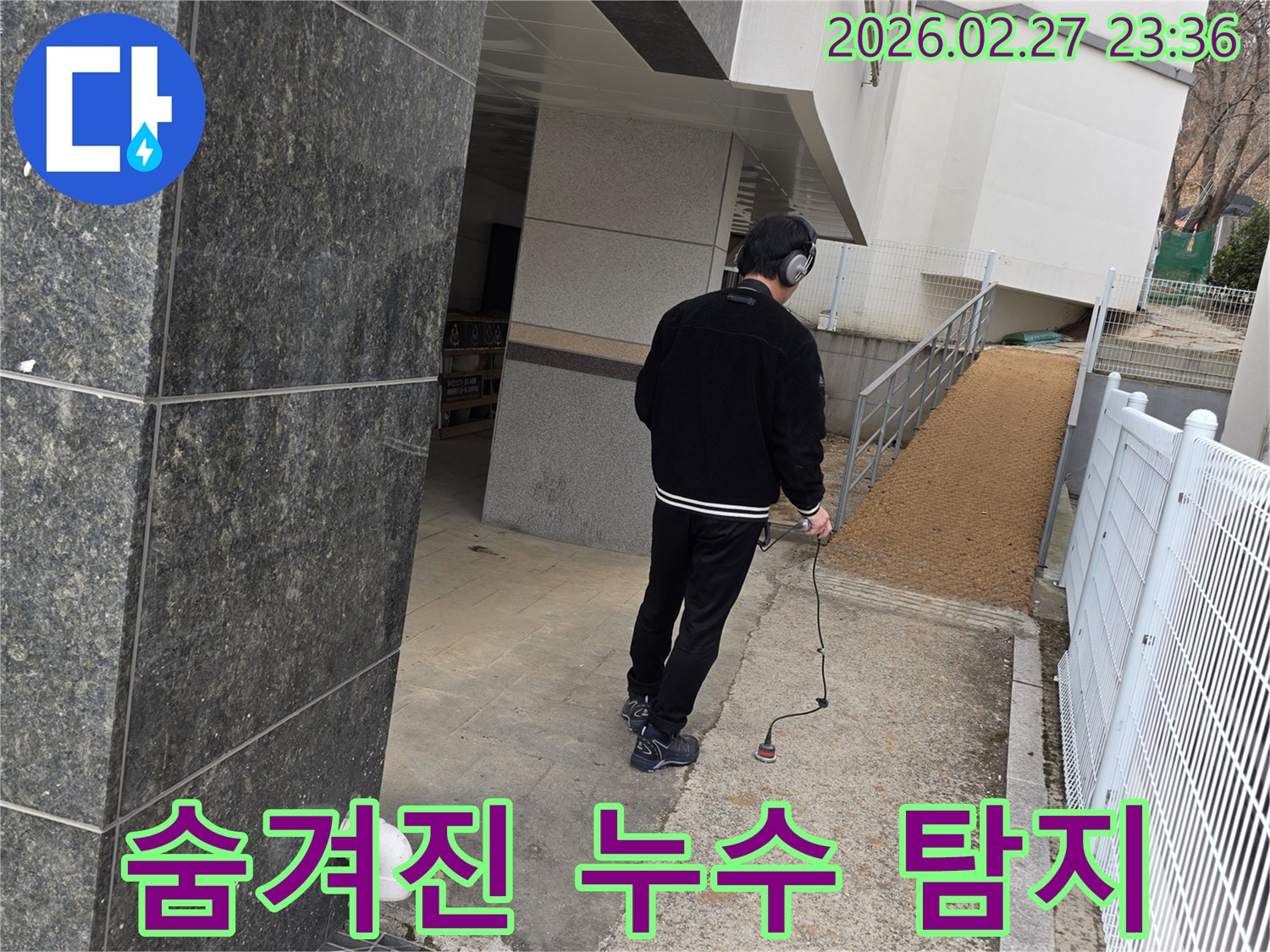 누수 전문가가-청음식 탐지 장비로-건물 외부의-숨겨진 누수 지점을 정밀하게 찾아내는 모습