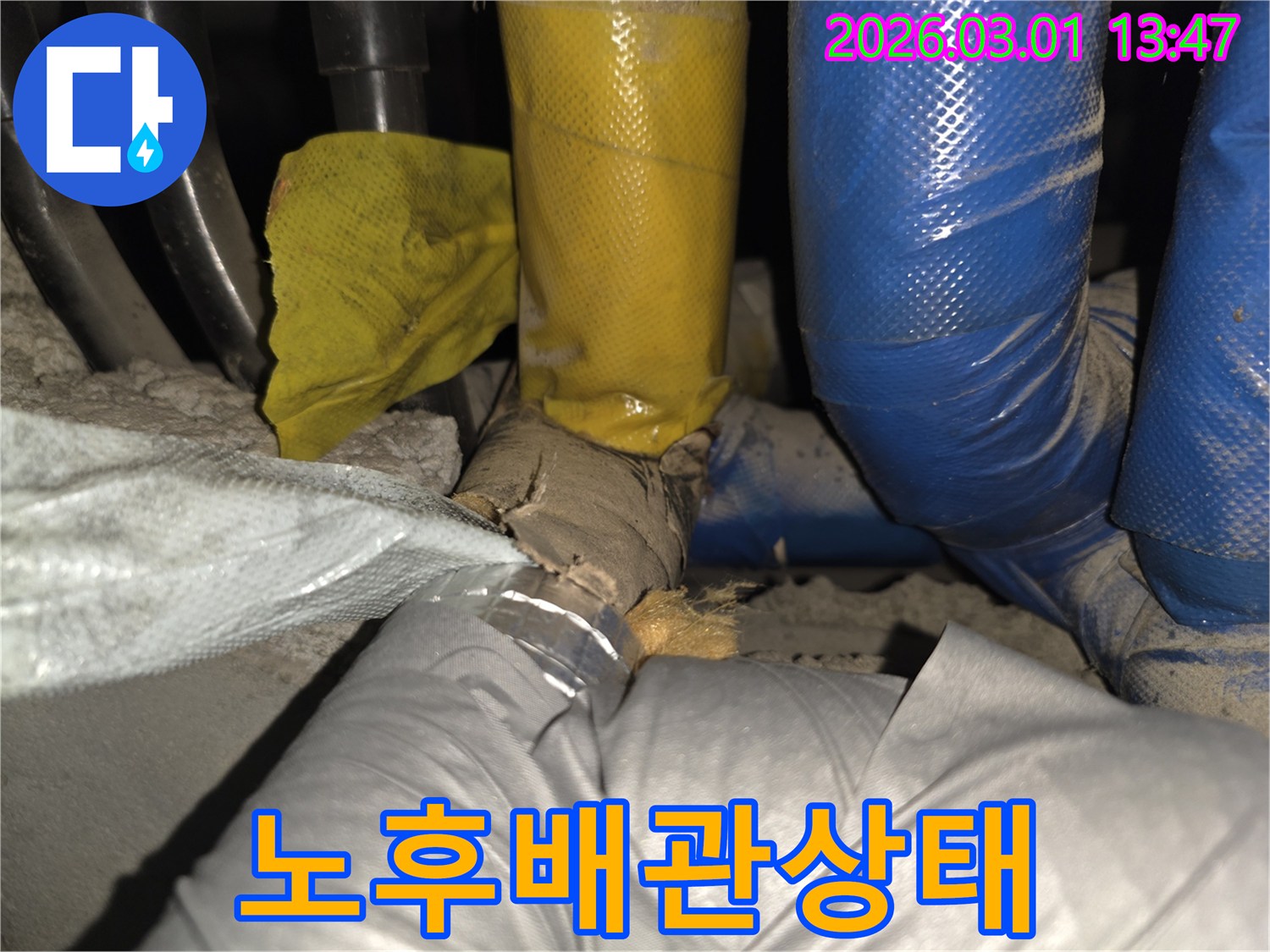 손상된 배관 단열재를 통해-습기 침투 및 누수 가능성을 시사하는 현장 사진입니다.