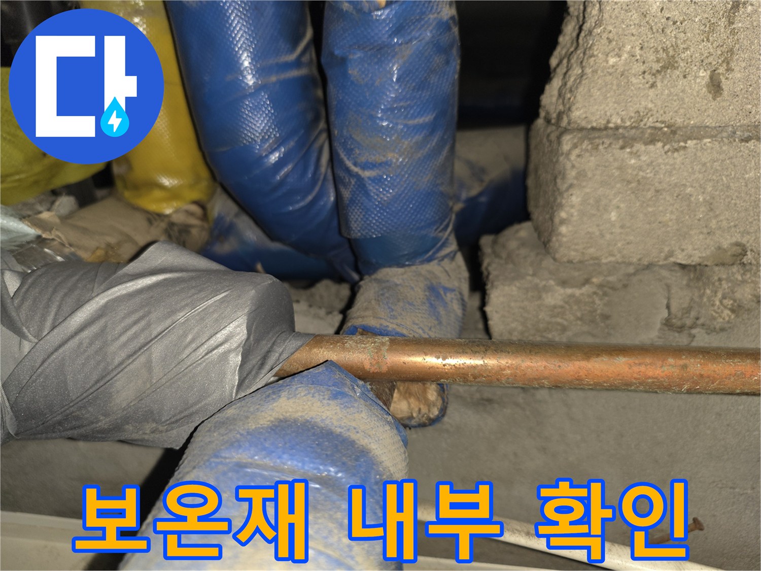 파란색 보온재와 구리 배관의 접합 부위 근접 촬영