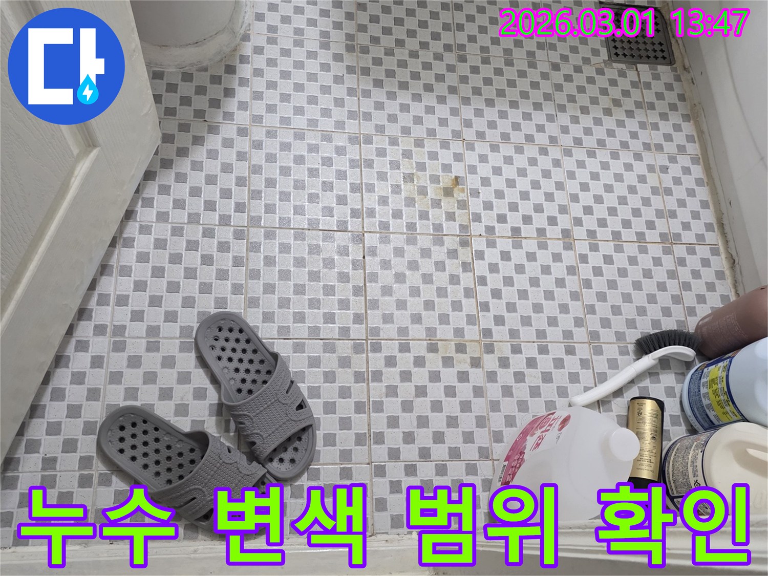 화장실 바닥-타일의-변색된-부분과-깨끗한-부분의-대비를-통해-누수-영향-범위를-파악하는-장면
