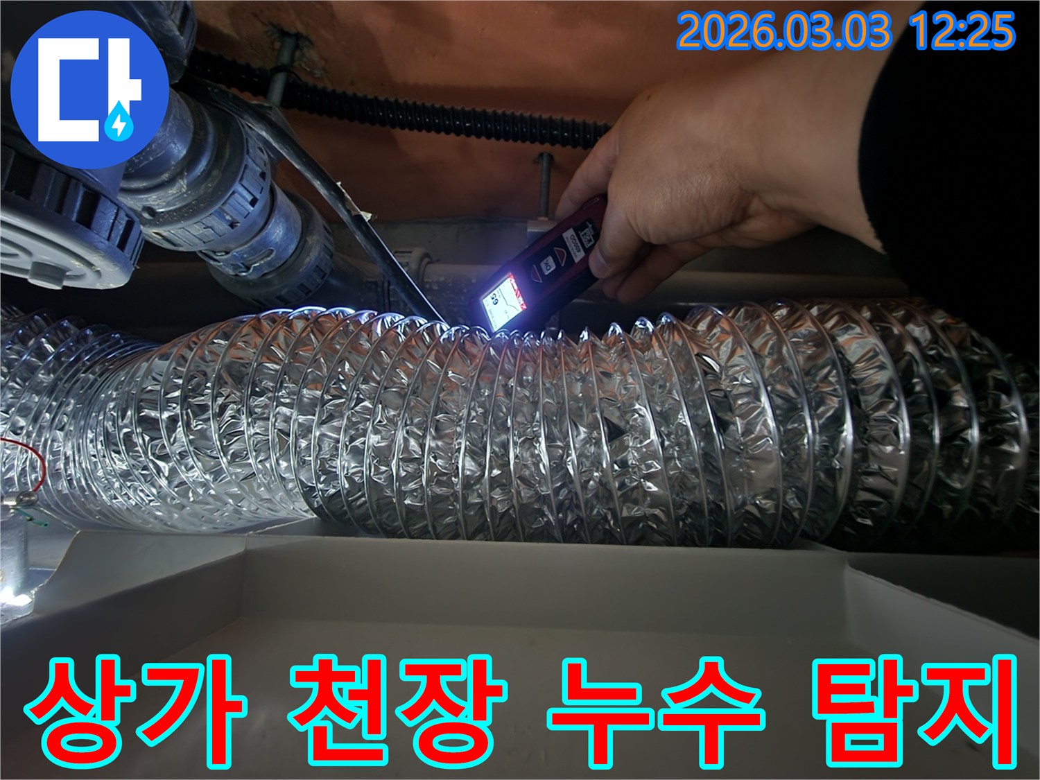 누수 전문가가-고성능 탐지기로-상가 천장 내부의-누수 지점을 정밀하게 확인하는 모습