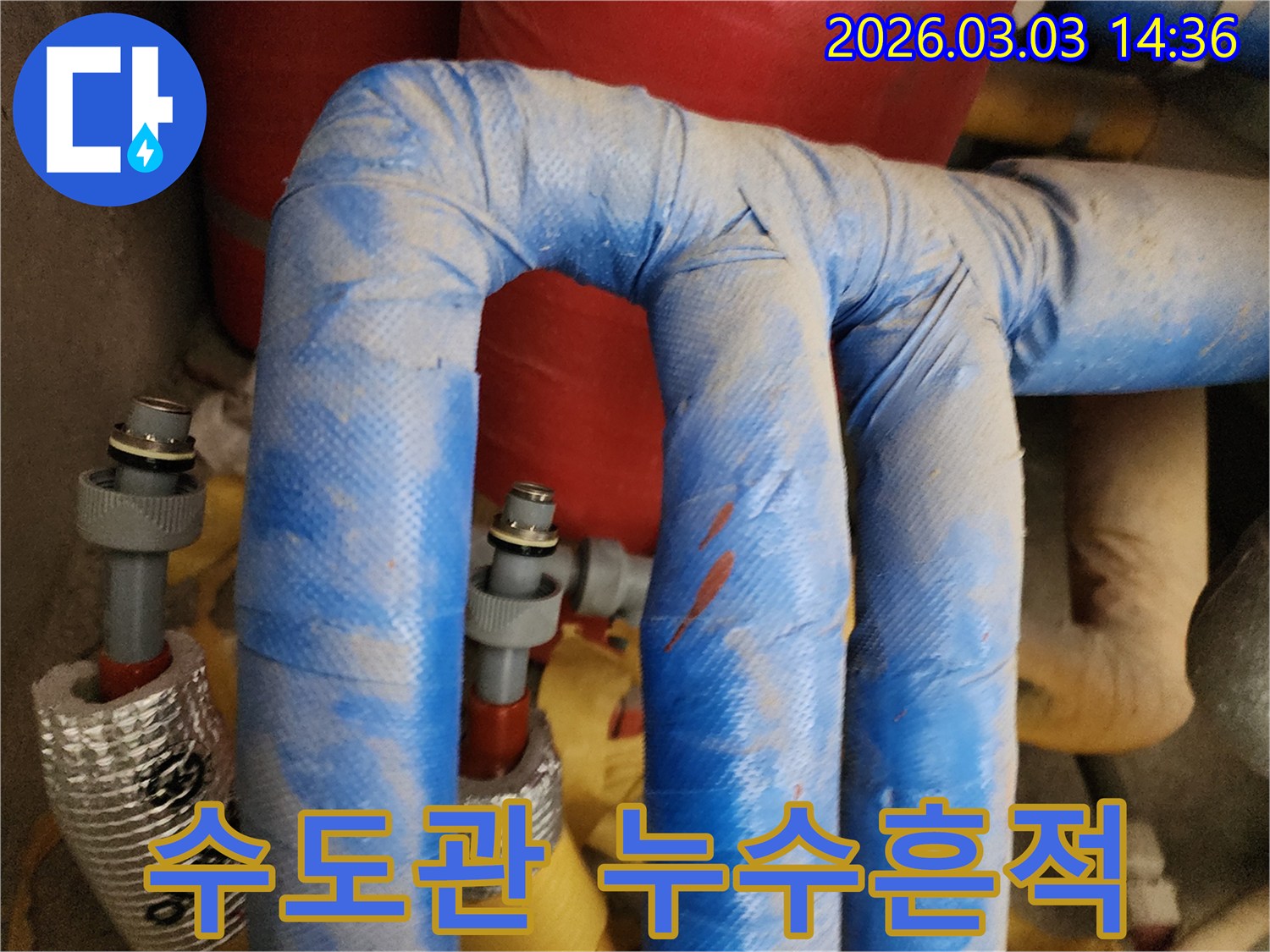 수도 배관의-파란색 단열재에-물이 스며들어-변색된-부분과-주변의-물기를-보여줍니다.