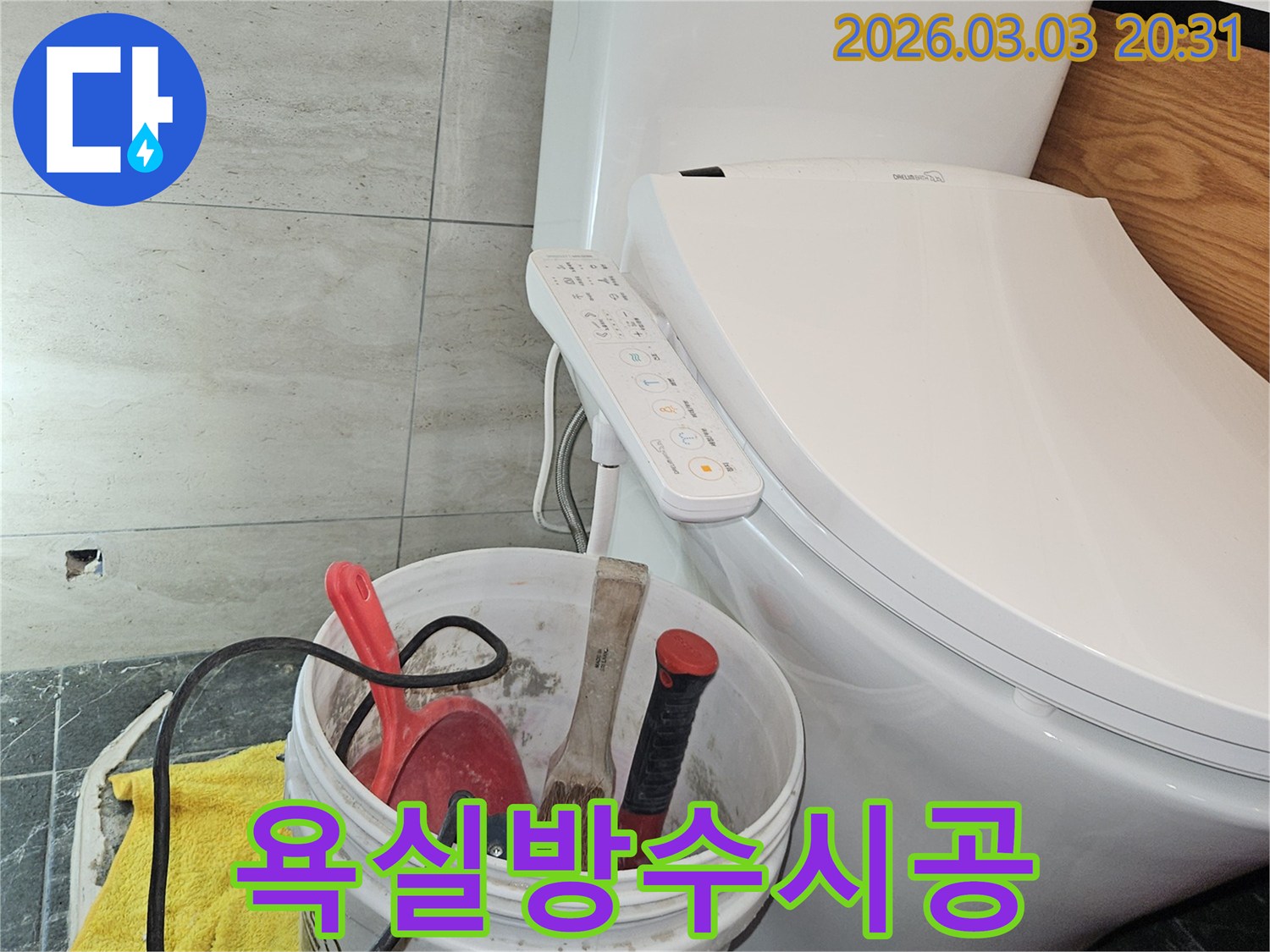 누수 공사를 위해 가져온 장비들이-화장실 변기 옆에 가지런히 놓여-작업 시작을 알리는 모습입니다.