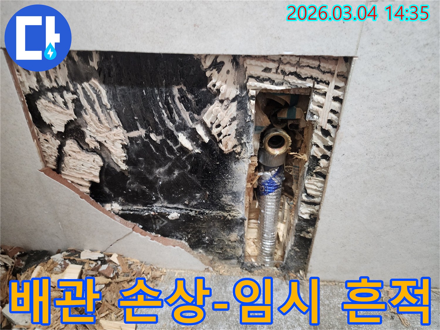 벽면을-개방하여-드러난-배관의-손상-부위와-이전에-누수를-막기-위해-시도했던-임시-조치의-흔적을-보여주는-사진