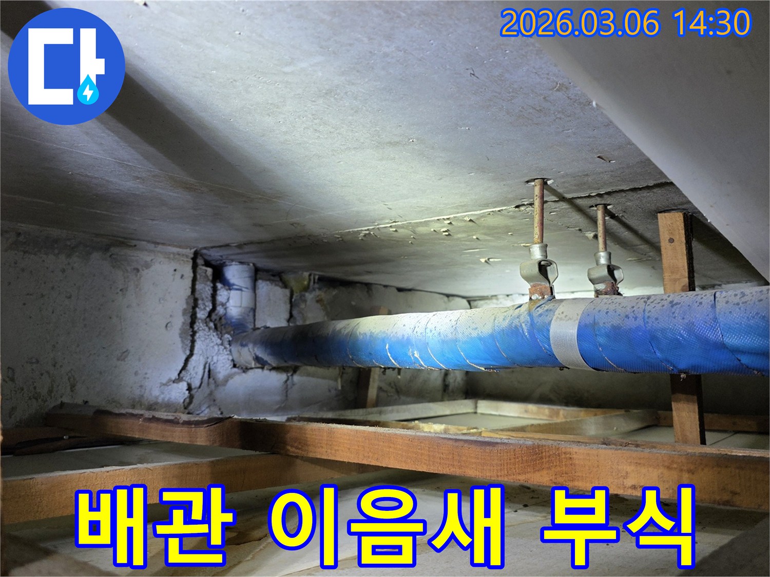 지하 공간의 파란색 배관-이음새 부분에서-누수로 인한 부식과-물샘 흔적이 보이는-현장 사진