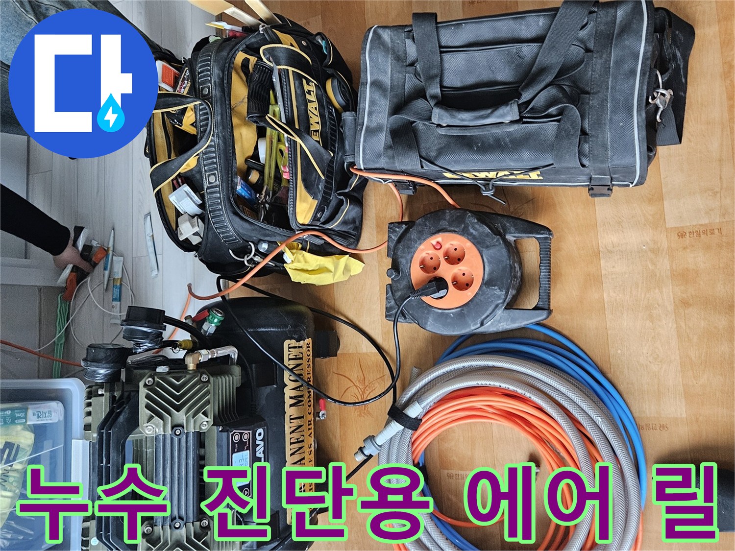 주황색과 파란색 호스가 감겨 있는 에어 릴과 압력계 장비