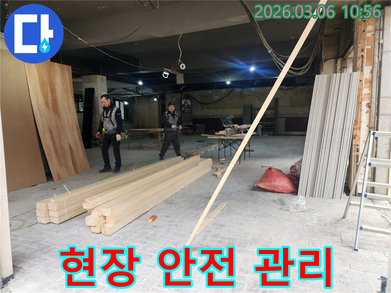 누수 공사 현장에서-작업자들이 안전 장비를 확인하고-작업 공간의 위험 요소를 점검하는 모습