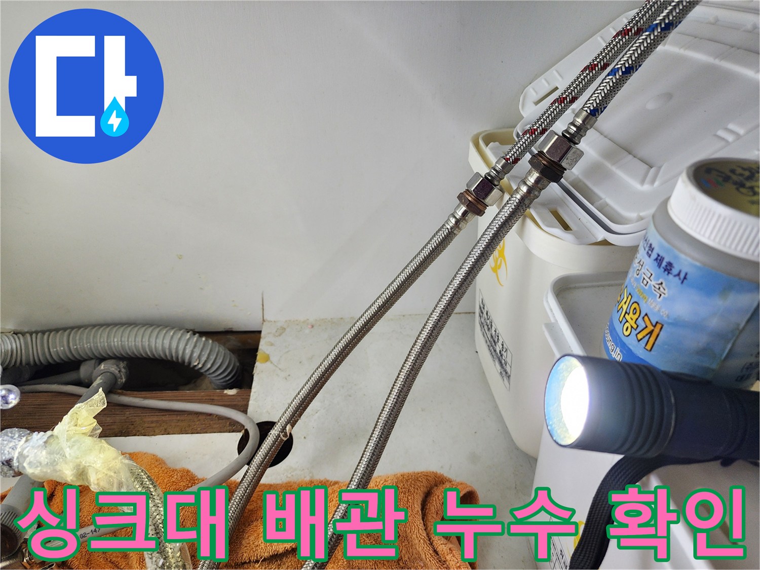 손전등으로 비춘 싱크대 하단 앵글밸브 연결 호스