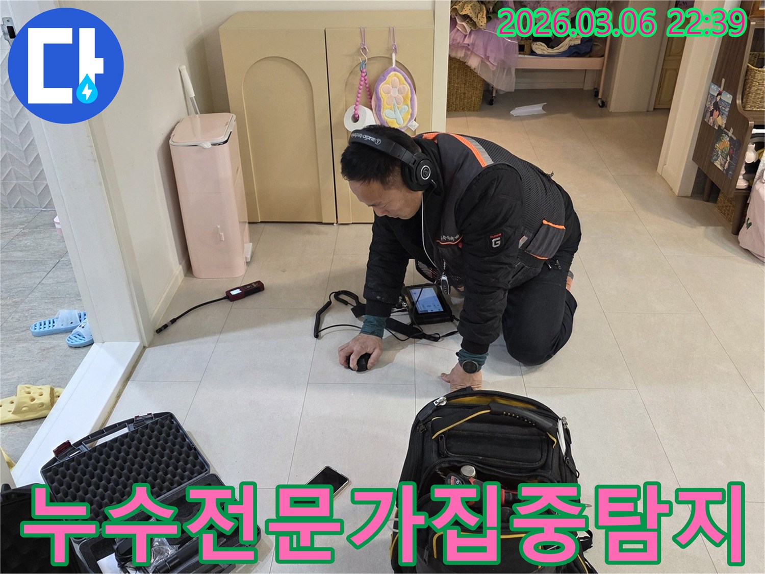 누수-전문가가-고성능-음향-탐지-장비를-활용하여-바닥에-엎드려-숨겨진-누수-지점을-찾기-위해-깊이-집중하고-있습니다.