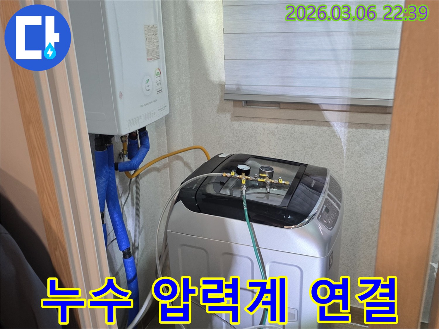 수도관-누수-여부를-확인하기-위해-세탁기-옆-배관에-압력-측정-장비를-설치하고-있는-사진