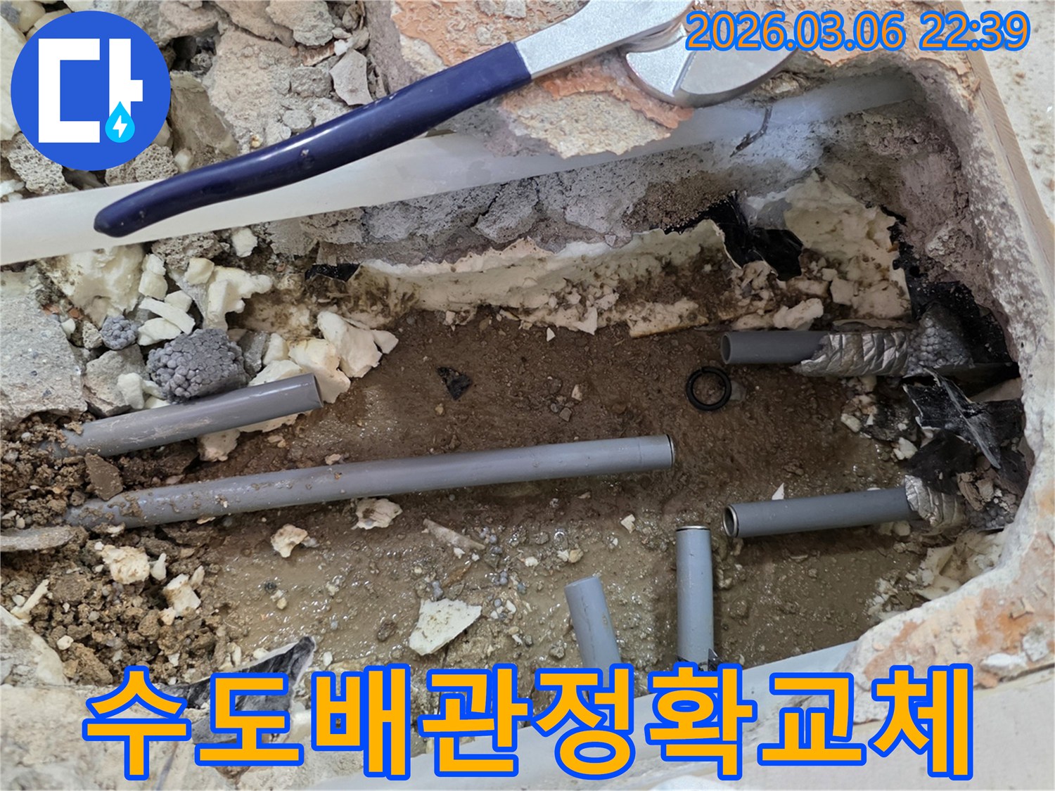 이 사진은 수도 배관에서 발생한 누수를 해결하기 위해-바닥을 개방하고 손상된 배관을 새로운 것으로 교체하는 현장을 보여줍니다