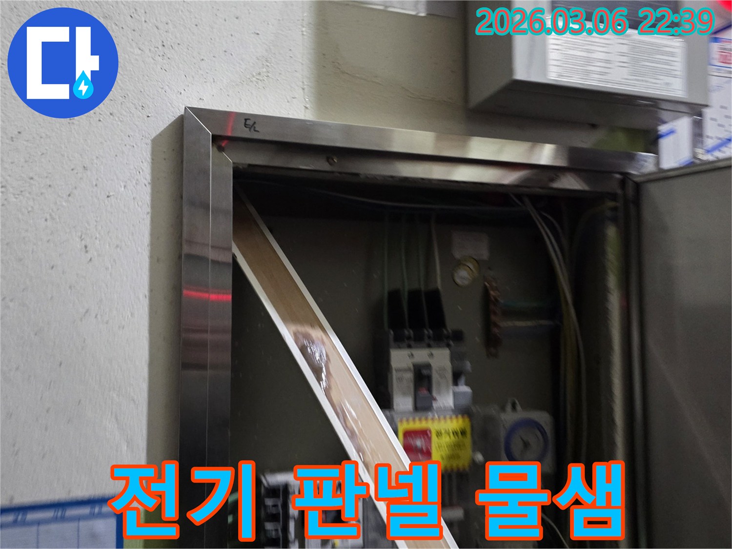 전기 판넬 내부로 스며든 물이-전기 부품들을 적시고 있는 모습으로-누수 문제의 심각성을-시각적으로 보여줍니다.